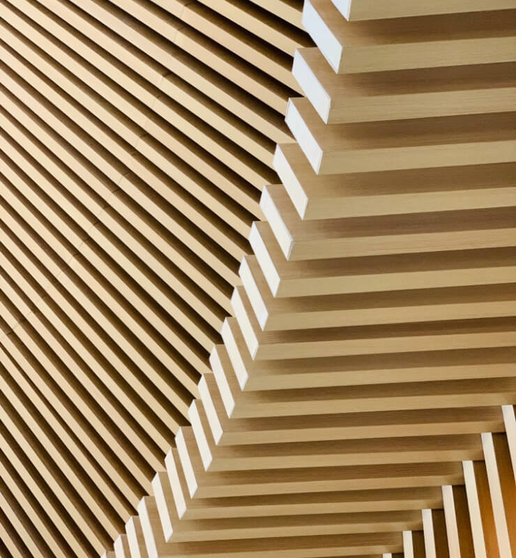 The ceiling of a building is made of wood slats.